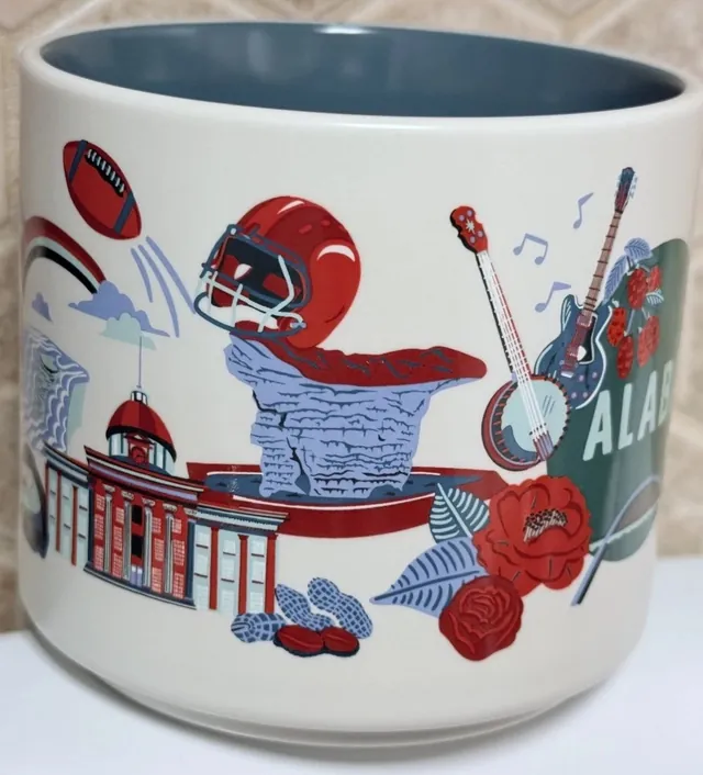 Starbucks Discovery Series Alabama mug with guitars, red camellias, red berries, a red propeller plane and a waterfall around the word ALABAMA — side view