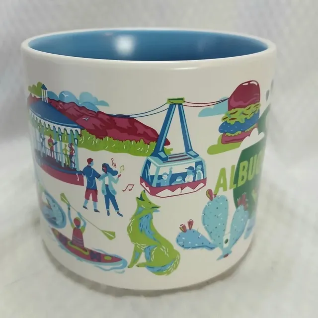 Starbucks Discovery Series Albuquerque mug with hot air balloons, a lizard, a prickly pear cactus and a dancer around the word ALBUQUERQUE — side view