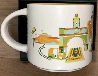 Starbucks Discovery Series Antigua Guatemala mug with a green bird, a volcano and a church facade around the words ANTIGUA GUATEMALA — side view