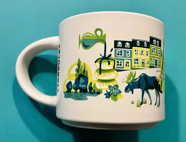 Starbucks Discovery Series Atlantic Canada mug with a lobster, a lobster trap and a golfer around the words ATLANTIC CANADA — back view