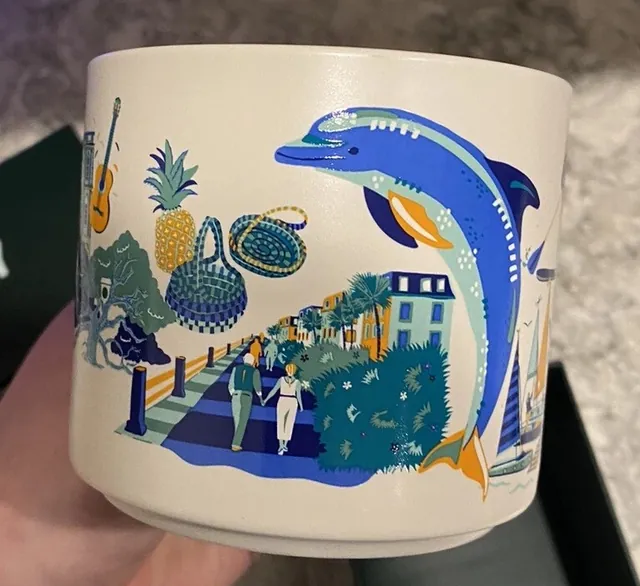 Starbucks Discovery Series Charleston mug with a paddleboarder, a heron, pastel row houses and a horse-drawn carriage around the word CHARLESTON — side view
