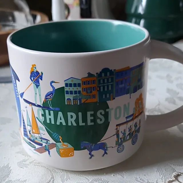 Starbucks Discovery Series Charleston mug with a paddleboarder, a heron, pastel row houses and a horse-drawn carriage around the word CHARLESTON
