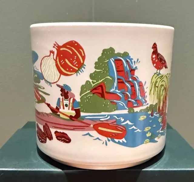 Starbucks Discovery Series Georgia mug with a peach, a frog, white flowers and a fish around the word GEORGIA — side view