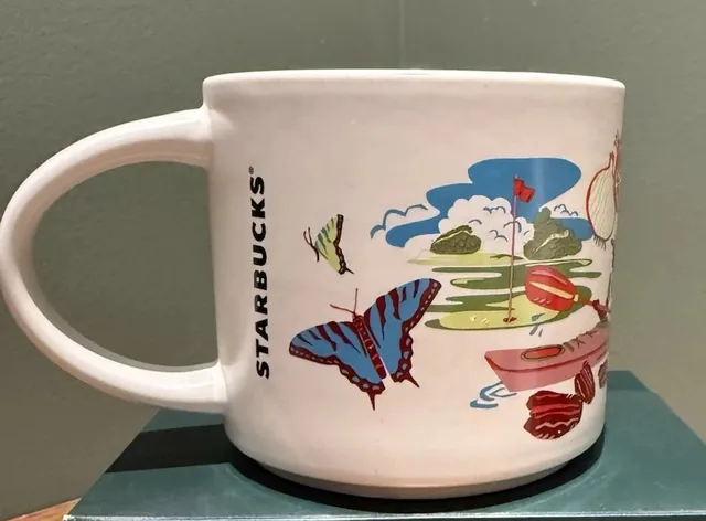 Starbucks Discovery Series Georgia mug with a peach, a frog, white flowers and a fish around the word GEORGIA — back view