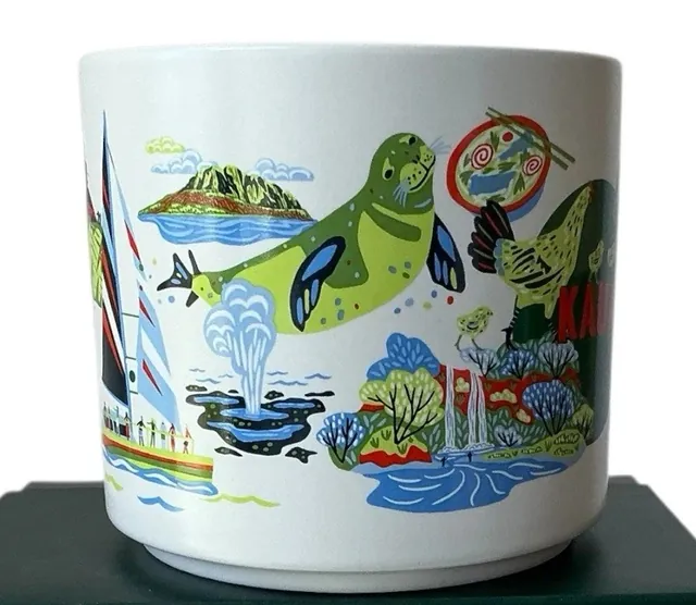 Starbucks Discovery Series Kauai mug with red KAUAI lettering, a green rooster with two chicks, a mountain and a red car — side view
