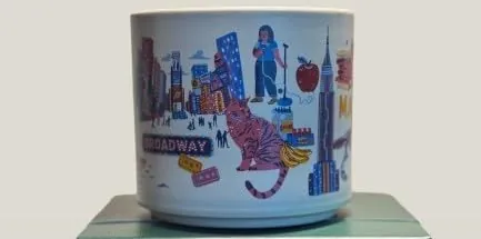 Starbucks Discovery Series Manhattan mug with a sandwich, a food cart, a saxophone, a dinosaur skeleton and a skyscraper around the word MANHATTAN — side view