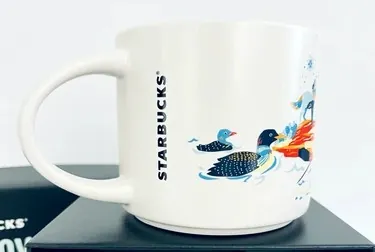 Starbucks Discovery Series Minnesota mug with a lift bridge, hockey player, apples and a skier around the word MINNESOTA — back view