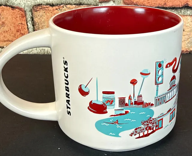 Starbucks Discovery Series Ohio mug with red carnations, a ladybug, a cardinal, a red barn, a football player and a bowl of pasta around the word OHIO — back view