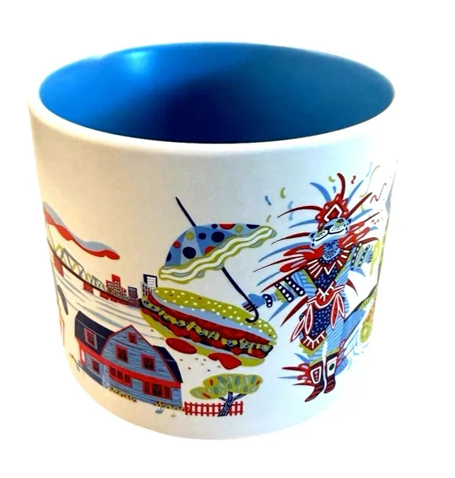 Starbucks Discovery Series Pennsylvania mug with a cracked bell, a blue bird, a chocolate bar and a fish around the word PENNSYLVANIA — side view