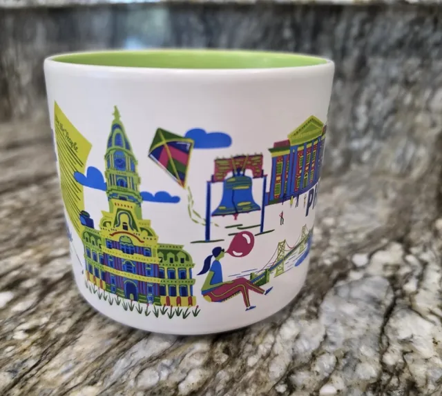 Starbucks Discovery Series Philadelphia mug with a loaded sandwich, a boxer in pink gloves and a pink skyline around the word PHILADELPHIA — side view