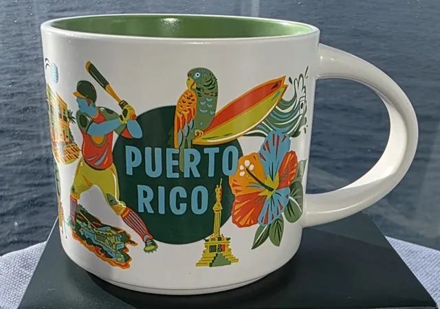 Starbucks Discovery Series Puerto Rico mug with blue PUERTO RICO lettering, a baseball batter, a parrot, a surfboard and a hibiscus flower