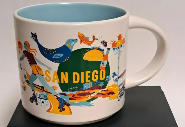 Starbucks Discovery Series San Diego mug with a roller skater, sea lion, orange fish, taco, palm trees and lifeguard tower around the words SAN DIEGO