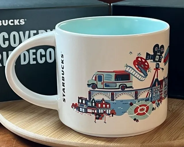 Starbucks Discovery Series Toronto mug with a bicycle, an arch bridge, a streetcar and red cliffs around the word TORONTO — back view
