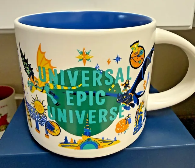 Starbucks Discovery Series Universal Epic Universe mug with two dragons, an orange creature and teal lettering over a green circle