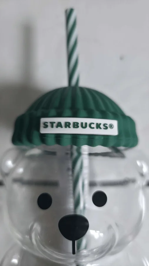 Close-up of the hat label: raised white 'STARBUCKS®' on a ribbed green beanie.