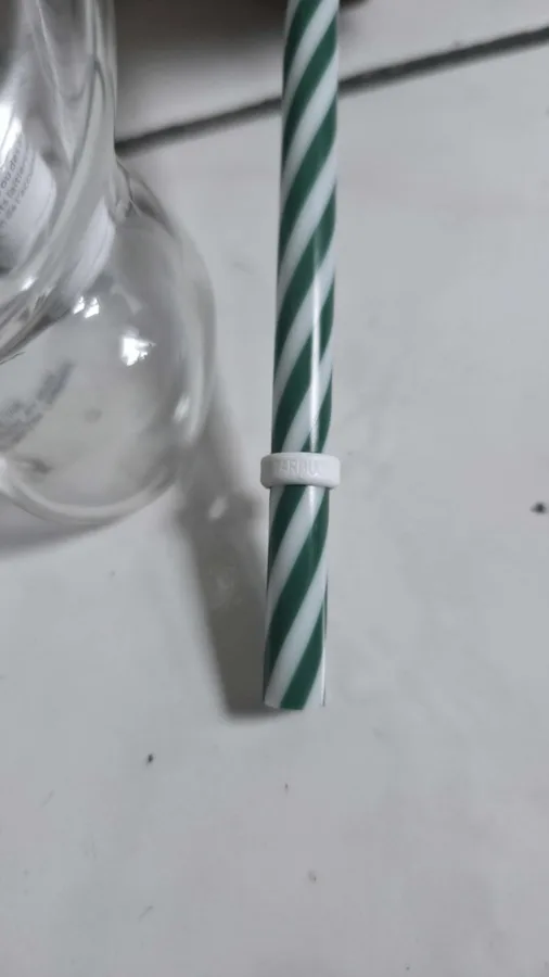 The straw with its white ring (stopper) and green-and-white spiral.