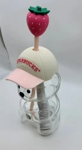 Starbucks Pink Bearista glass cold cup, a bear-shaped glass cup with a cream cap-style hat and a strawberry straw topper, side view