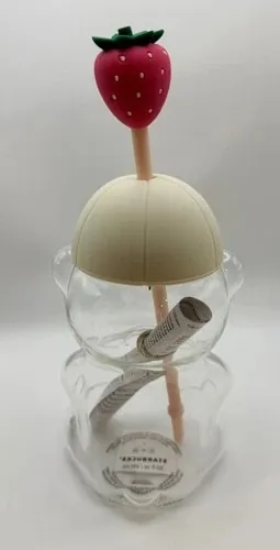 Starbucks Pink Bearista glass cold cup, a bear-shaped glass cup with a cream cap-style hat and a strawberry straw topper, back view