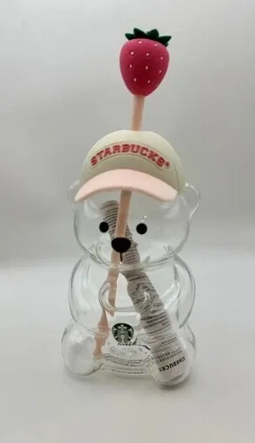 Starbucks Pink Bearista glass cold cup, a bear-shaped glass cup with a cream cap-style hat and a strawberry straw topper