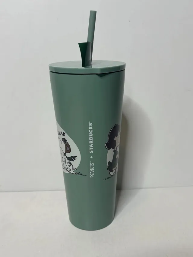 Starbucks Peanuts stainless steel cold cup in green with Lucy and Snoopy art and a PEANUTS + STARBUCKS hang tag on the straw, back view