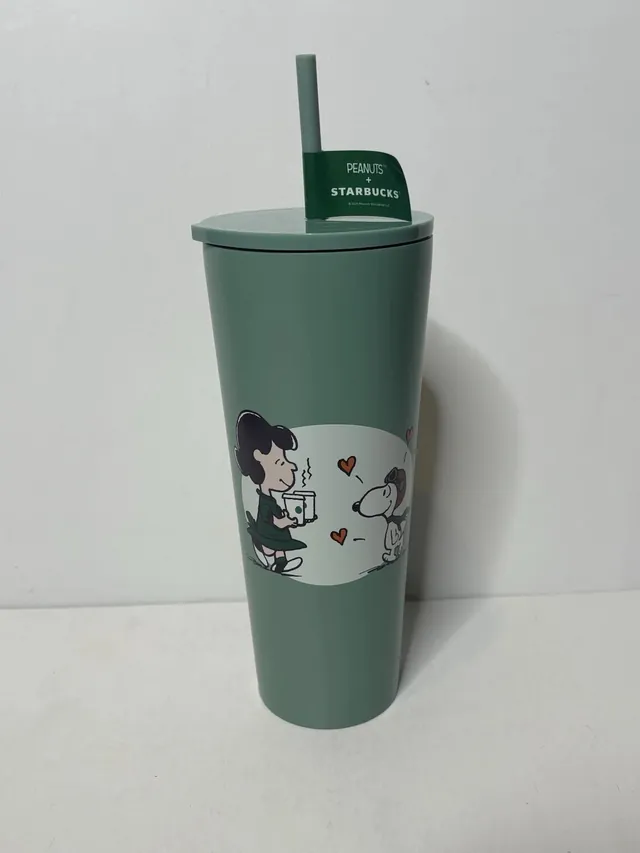 Starbucks Peanuts stainless steel cold cup in green with Lucy and Snoopy art and a PEANUTS + STARBUCKS hang tag on the straw