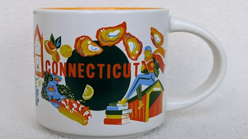 Connecticut Starbucks mug featuring oysters, books, and a lighthouse with a runner, highlighting the state's history, cuisine, and outdoor activities.