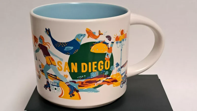 San Diego Starbucks mug with images of a roller skater, palm trees, lighthouse, and beach scene.