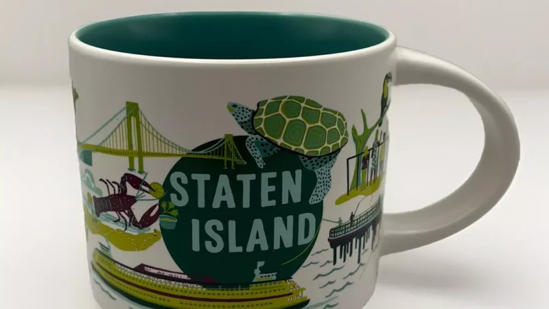 Staten Island Starbucks mug with images of a turtle, ferry, lobster, and toucan.