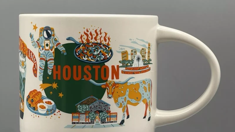 Houston Starbucks mug showing an astronaut, cowboy boots, longhorn cattle, Houston skyline, and a space shuttle.