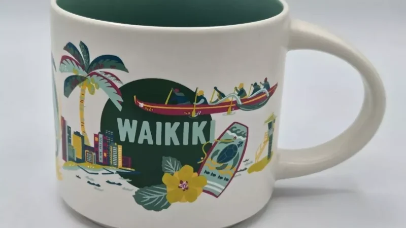 Waikiki Starbucks mug with images of palm trees, surfboards, canoe, and tropical scenes.