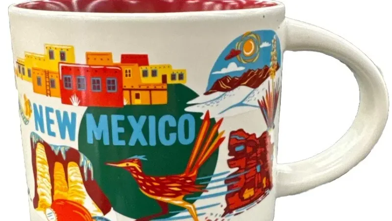 New Mexico Starbucks mug featuring adobe houses, a roadrunner, hot air balloons, a red chili pepper, and a "Welcome to Roswell" sign.