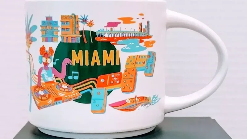 Front view of Starbucks Miami Discovery Series mug showing flamingos, domino tiles, and DJ booth