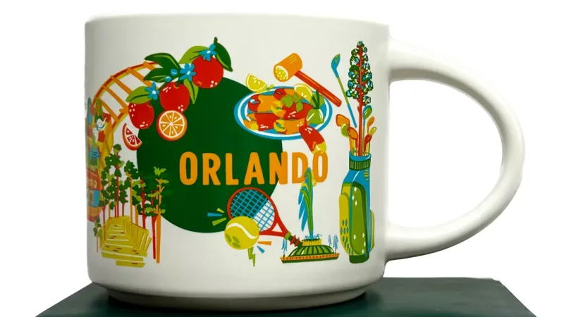 Starbucks Orlando Discovery Series mug showcasing amusement park rides, tennis racquet, and golf clubs.