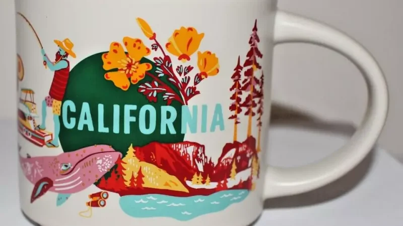 California Starbucks mug with images of the Golden Gate Bridge, redwood trees, surfer, bear, grapes, and a Hollywood film clapperboard.