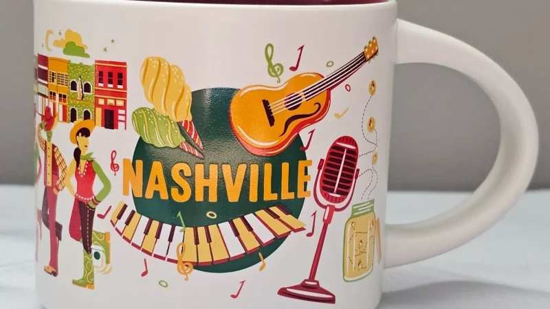 Nashville Starbucks mug with images of a guitar, cowboy hats, fireflies in a mason jar, and musical notes.