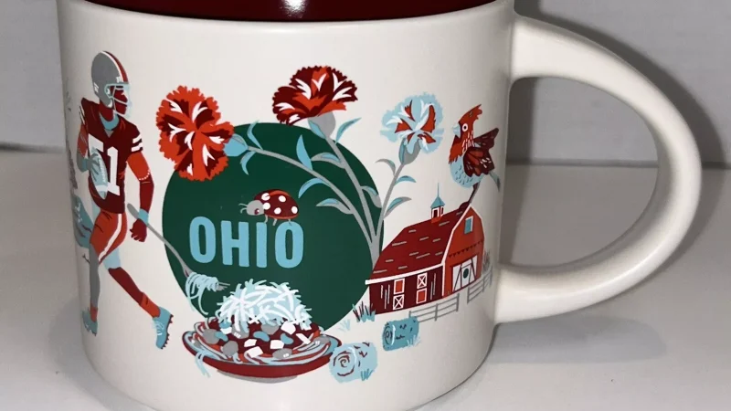 Ohio Starbucks mug displaying a football player, red barn, state flower carnations, and lighthouse.