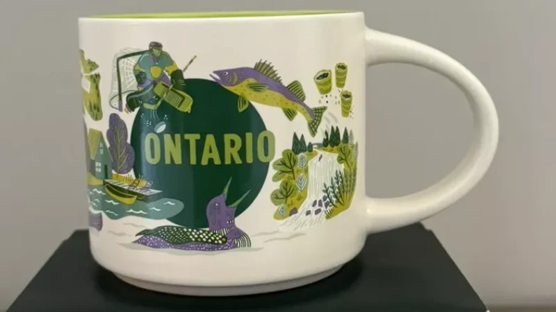 Ontario Starbucks mug with images of a hockey player, fish, canoe, green plants, and a stylized map.