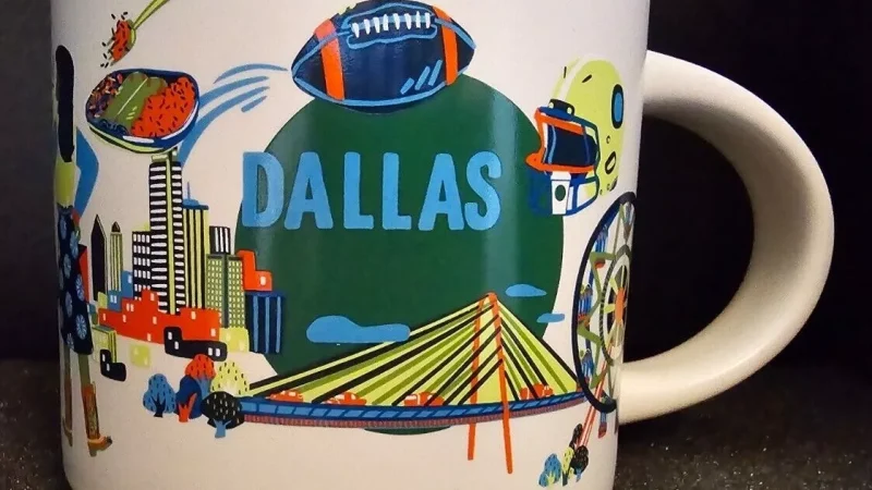 Dallas Starbucks mug showing cowboy boots, a longhorn cow, football symbols, city skyline, and a Ferris wheel.