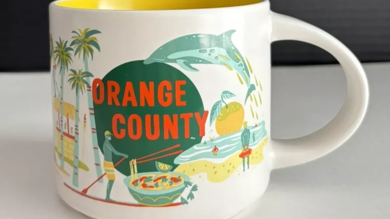 Orange County Starbucks mug with a dolphin, palm trees, ferris wheel, and colorful beach houses.