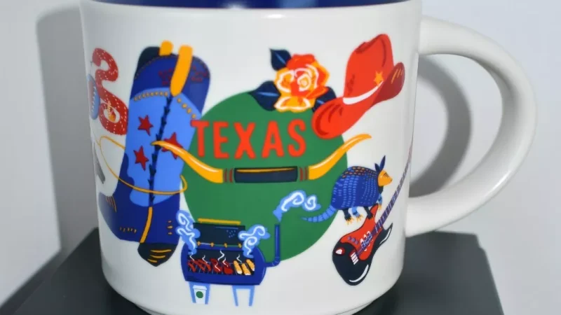 Texas Starbucks mug displaying an astronaut, cowboy boot, space shuttle, and Texan cuisine.