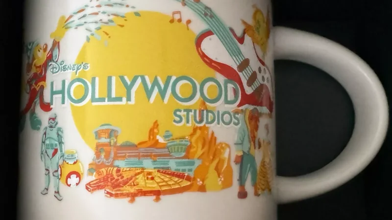 Hollywood Studios Starbucks mug with images of a film reel, Millennium Falcon, guitar, and musical notes.