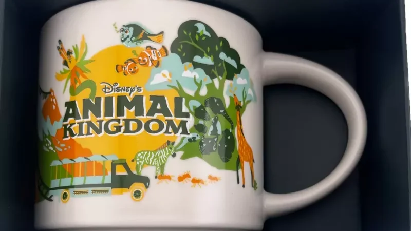 Animal Kingdom Starbucks mug with illustrations of giraffes, flamingos, zebras, a safari vehicle, and Disney-themed elements.